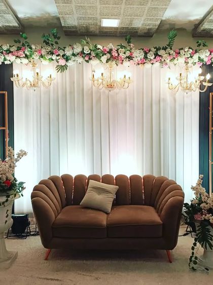 A sophisticated stage design for an engagement or reception at Celebration banquet hall in Juinagar. The dark backdrop with warm lighting creates a very classy look.