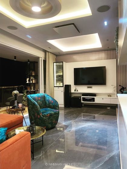 This smart living room at Bhagwati Greens features a fully automated home theatre system. The ceiling-mounted projector and in-built speakers offer a cinematic experience without compromising on aesthetics.