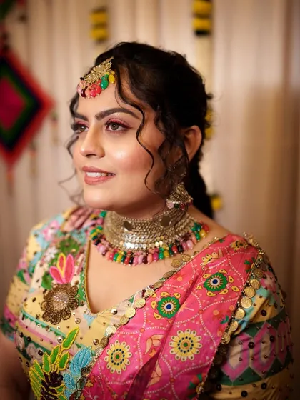 A side profile of the Haldi look, showing how the pink eyeliner adds a fun pop of color. The skin is kept glowing and fresh to match the festive occasion.