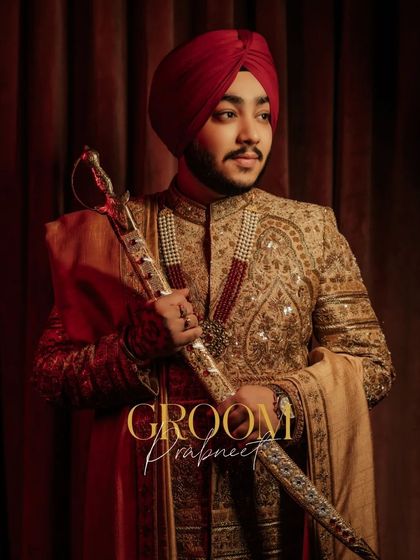 A regal portrait of the groom, Prabneet, in his golden sherwani and red turban, holding his kirpan with pride.