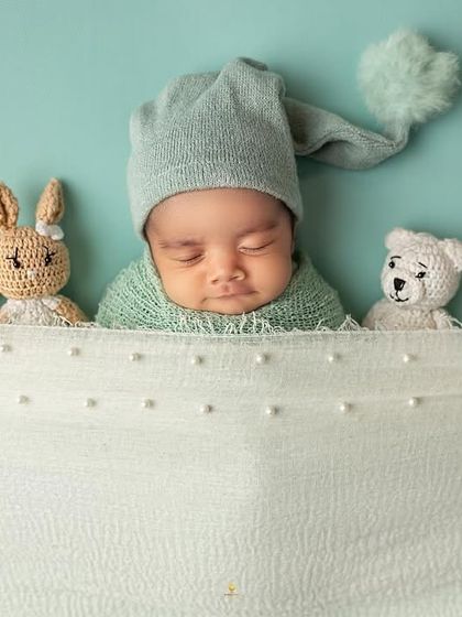 Tucked in and dreaming, this baby is surrounded by a lineup of tiny, knitted animal friends. It’s a sweet and simple composition that is full of charm.
