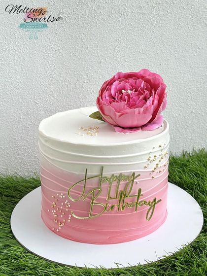 A classic design in pink and white. This whipped cream cake features a lovely ombre effect and is topped with a large pink peony, making it simple yet stunning.