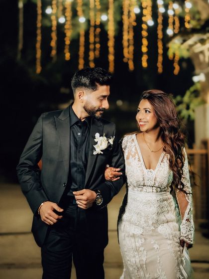 The couple sharing a happy moment while walking arm-in-arm at their evening reception. I use the background lighting to create a beautiful bokeh effect.