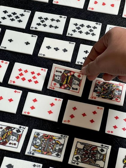 A close-up of the intricately detailed ceramic playing cards. The level of craftsmanship is just insane.