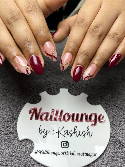 An elegant deep red set with sheer accent nails featuring delicate gold glitter swirls.