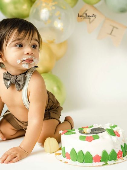 Pausing for a moment to survey the delicious mess. This candid shot shows the playful aftermath of a fun and successful cake smash.