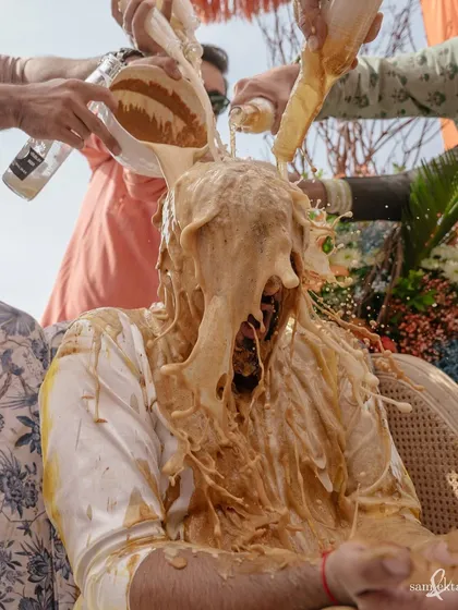 Maahir gets the full haldi treatment, marinated in beer, curd, and turmeric. This photo captures the absolute peak of haldi madness, a moment of complete surrender to the celebration.