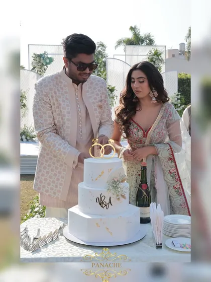 The cake cutting ceremony, a sweet moment to mark their engagement. The elegant three-tiered cake was designed to match the white and gold theme.