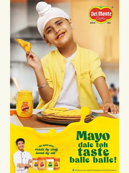 Featuring a young boy enjoying a paratha with mayonnaise, this Del Monte campaign image connects with a family audience. The bright, happy expression and simple setup make the product feel accessible and perfect for any meal.