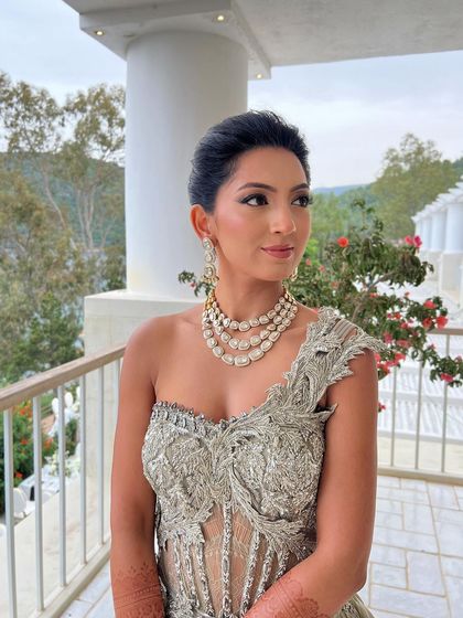 A sophisticated French knot updo for a cocktail event, offering a very clean, modern, and high-fashion look.