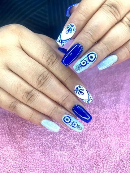 A striking evil eye design in royal blue and white. I combine the popular motif with other patterns for a unique, protective manicure.