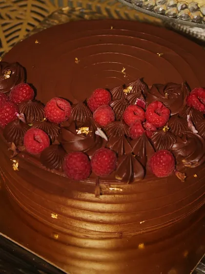 A showstopping Dark Chocolate & Raspberry Torte. The rich chocolate is perfectly balanced by the tartness of the fresh raspberries, making it a truly decadent dessert.