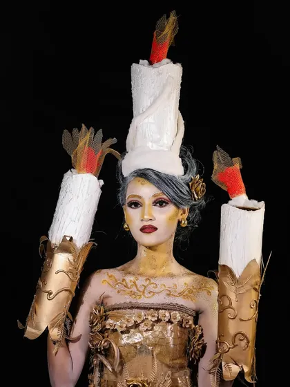 A powerful portrait of the candle look, demonstrating how to use lighting to enhance the metallic and shimmering textures of the makeup.