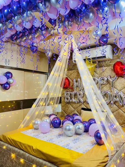 This image captures the full effect of the purple and silver balloon ceiling and the glowing bed canopy.