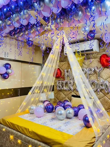 This image captures the full effect of the purple and silver balloon ceiling and the glowing bed canopy.