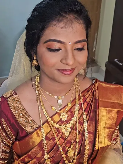 A Christian wedding look with a traditional maroon saree and a white veil. The makeup is a beautiful fusion of classic and modern styles.