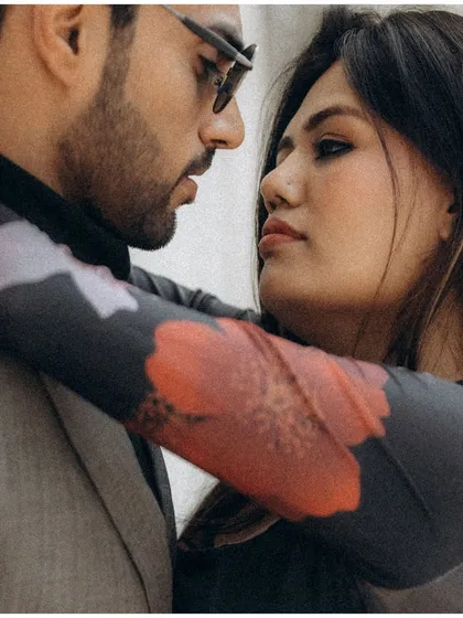 An intense, intimate close up. The grainy texture and tight framing draw you into their private world, a quiet moment shared amidst the bustling city.