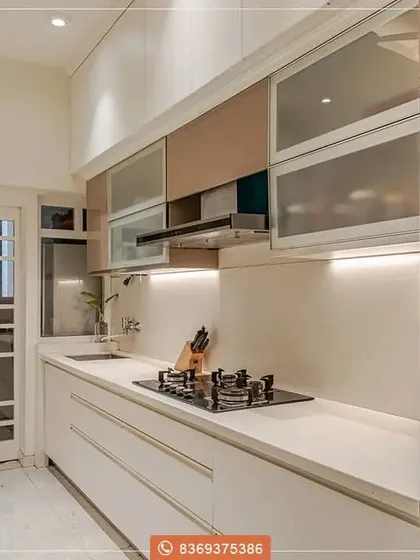 This compact kitchen design maximizes space without compromising on style. We used handleless white cabinetry and frosted glass upper cabinets to create a bright, airy feel, with integrated appliances for a sleek finish.