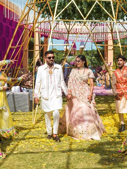 The couple makes their way through a pathway created by the dancers. This shot highlights the choreographed nature of the entry, making it feel like a performance.
