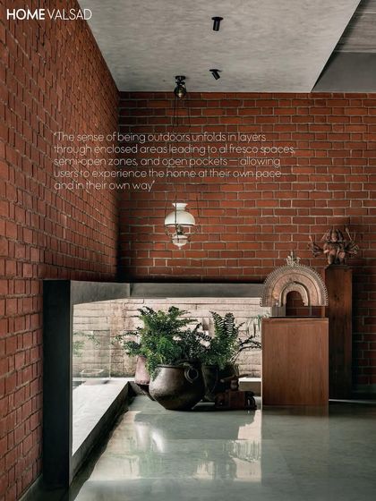 This magazine spread highlights how the sense of being outdoors unfolds in layers. The placement of potted plants in this interior nook provides a green view, connecting it to the larger garden spaces beyond.