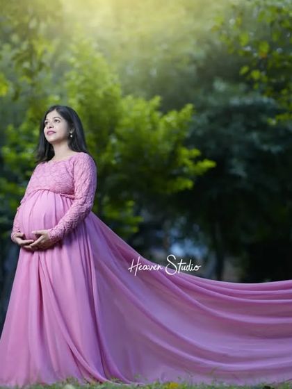 An enchanting outdoor portrait with a long, flowing pink gown trailing behind. The natural light and serene setting create a truly magical atmosphere.