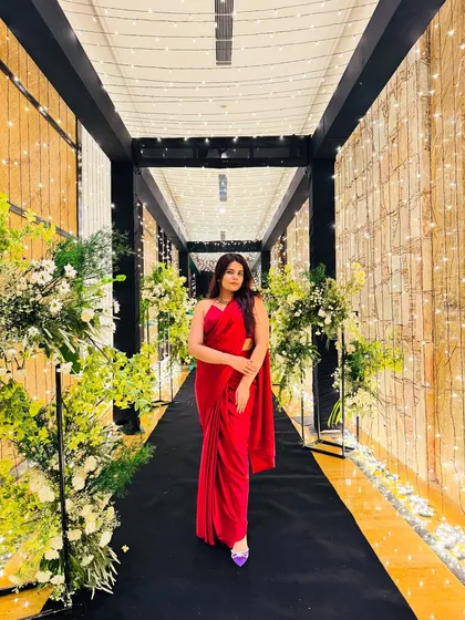 A classic red saree look for a wedding vibe. This elegant look was captured in a beautifully decorated hallway, perfect inspiration for a reception or cocktail party.