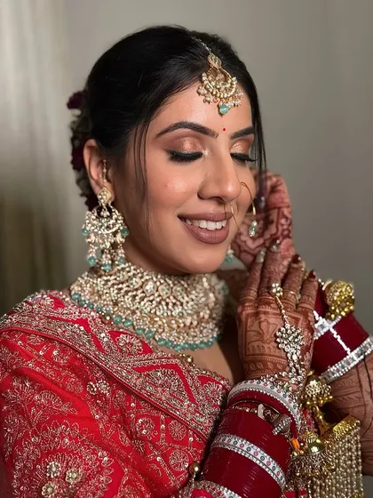 Adjusting her earring, this bride looks absolutely radiant. The makeup is designed to be flawless up close, with a smooth base and beautifully blended eyeshadow.