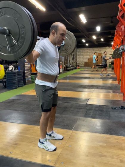 A client practicing the drop snatch. This exercise is purely about speed and getting under the bar quickly, which is crucial for successful snatches.