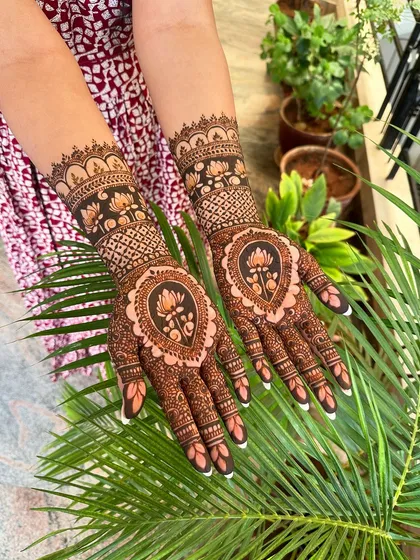 A stunning design where a lotus motif is framed within a paisley shape, combining two classic elements of Indian henna art for a beautiful result.