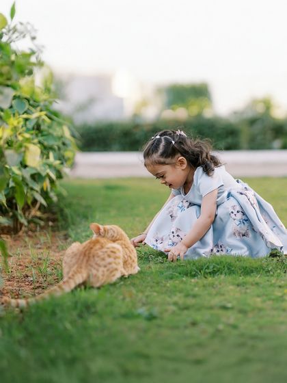 A little girl making friends with a stray cat during her outdoor session. Sometimes the most unexpected moments are the most beautiful.