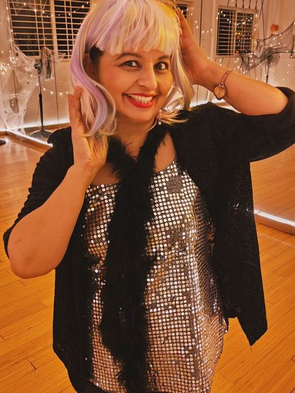 A student looking glamorous with a sequined top and colorful wig for our Halloween social. It's a night to dress up and shine.