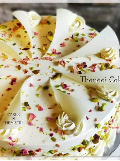 A beautifully decorated Thandai Cake for Holi. This cake is layered with thandai-flavoured cream and adorned with white chocolate shards, pistachios, and rose petals, making it both elegant and delicious.