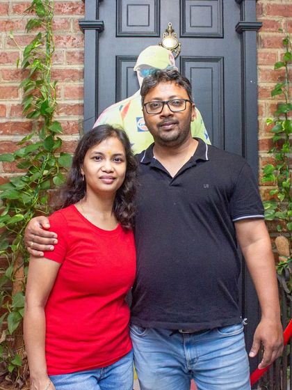 A couple posing in front of our cricket-themed decor.