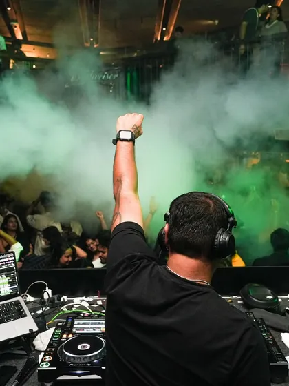 The view from my console is the best in the house. This shot captures that moment of connection with a packed floor, fist in the air, right before the beat drops. It's all about channeling that collective energy.