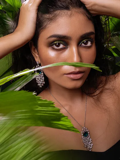 A direct and powerful gaze, where the dramatic eye makeup and sparkling jewellery create a captivating image.
