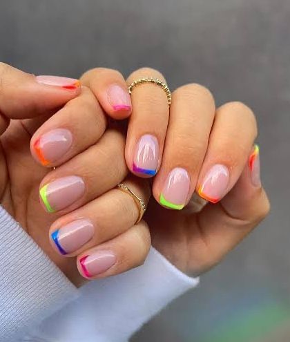 A minimalist take on rainbow nails for Holi. This design features a clean, short nail with a simple, colorful French tip that is both festive and chic.