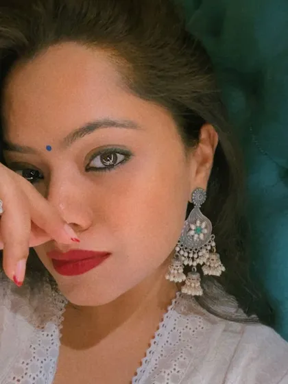 A close-up highlighting the power of accessorizing. The silver jewelry, bindi, and bold red lip complete this look, adding personality and strength to the traditional attire.