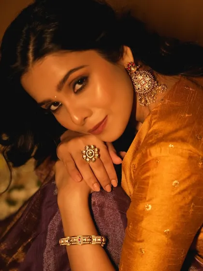 A close-up of Rashmi's makeup. You can see the clean skin work and the soft definition around the eyes, creating a look that is both festive and elegant.