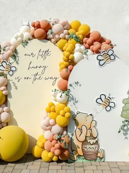 A closer look at the Winnie the Pooh backdrop, showing the cute bee details and custom calligraphy.