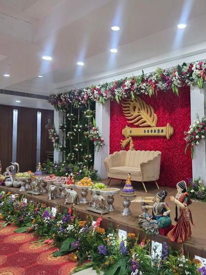 An angled shot of the Krishna flute stage, highlighting the surrounding greenery and offering table.
