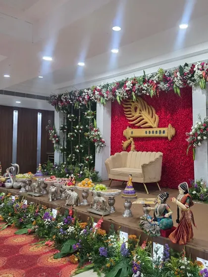 An angled shot of the Krishna flute stage, highlighting the surrounding greenery and offering table.