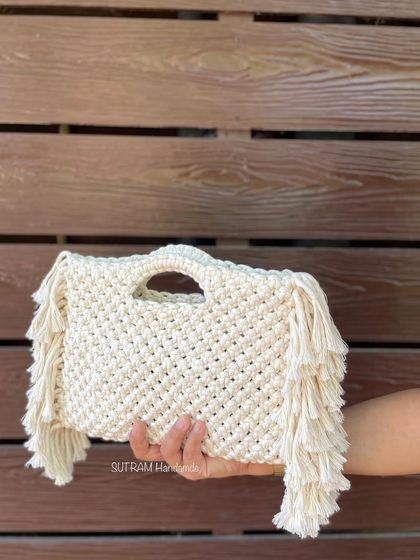 A close-up of the fringed boho bag. You can see the detailed knotting and the soft, thick fringes on the side. It's all handmade from cotton thread.