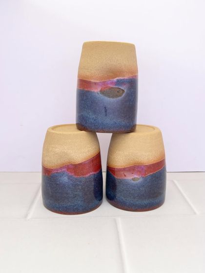 A trio of the Celestial Dunes grip mugs, stacked and ready to be used. Their shape is simple and modern, letting the glaze be the star.