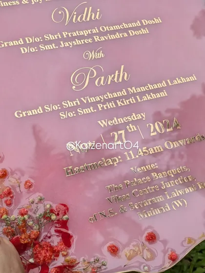 A detailed shot of the pink resin Kankotri, showing the elegant script and the placement of the dried flowers along the border.
