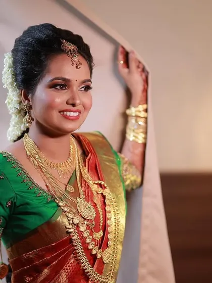 A picture of pure joy. For this South Indian bride, I created a classic look with a dewy base, defined eyes, and a bright smile. The makeup is designed to complement her beautiful Kanjeevaram saree and traditional gold jewellery, ensuring she looks timeless.