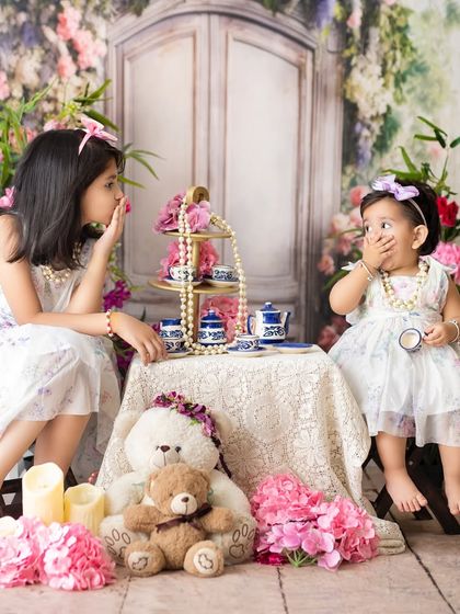 A playful sisters' tea party. Using props like this miniature tea set encourages imaginative play and results in adorable, candid photographs.