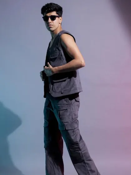A full-body shot capturing the model in motion. This helps to show the fit and cut of the cargo pants and vest while maintaining a cool, effortless energy.