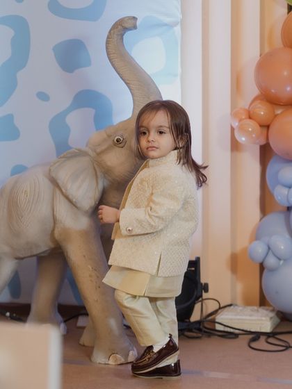 The little star of the Mundan ceremony, looking smart in his traditional outfit next to an elephant prop from our jungle theme.