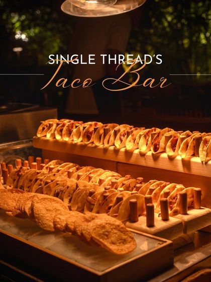 An evening view of the fully stocked taco bar, with rows of crispy and soft shells ready for service. The warm lighting and abundant display promise a delicious and engaging experience for everyone.