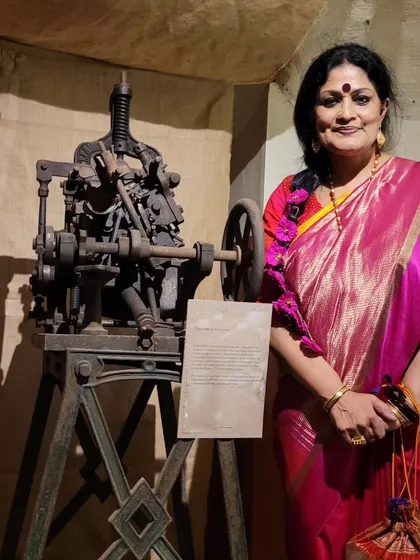 Posing with one of the antique manual printing presses at the HARAF Exhibition, a tangible link to the history of Bengali typography.